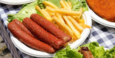 Pişmiş sosis ve marullu patates kızartması.
