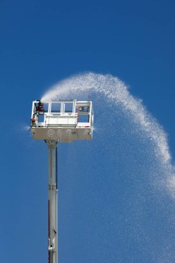 İnsanlar yokken bile suyu otomatik olarak püskürten itfaiye aracının hava platformu.