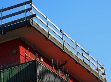 Dairenin çatısındaki bakım işleri sırasında işçilerin güvenliği için sıkıca yerleştirilmiş sağlam koruyucu bariyerin tahta kalasları.