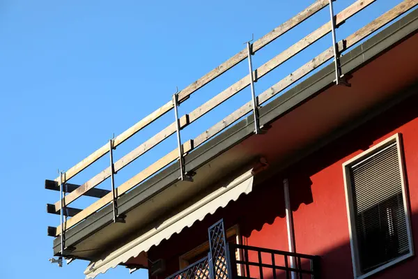 Dayanıklı koruyucu bariyerin ahşap kalasları işçilerin güvenliği için sıkıca yerleştirildi. Dairenin çatısında bakım sırasında insanlar olmadan düşmesinler diye.