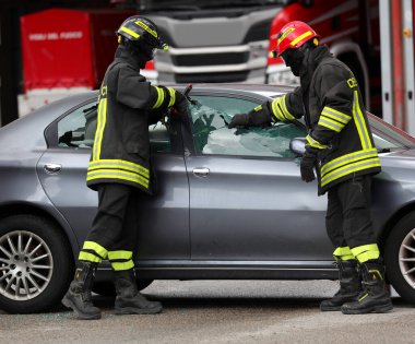 Vicenza, VI, İtalya - 22 Mayıs 2025: itfaiye ekipleri, yaralı kişiyi kurtarmak için kaza yapan bir arabanın camını kırdılar.