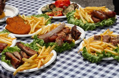 beyaz ve mavi kareli masa örtüsü ve bir sürü et ve patates kızartması