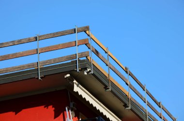 Ahşap bariyer, birçok kiremit fırtınasından sonra binanın çatısındaki tamirat sırasında işçilerin düşmesini önlemek için pratik bir çözümdür.