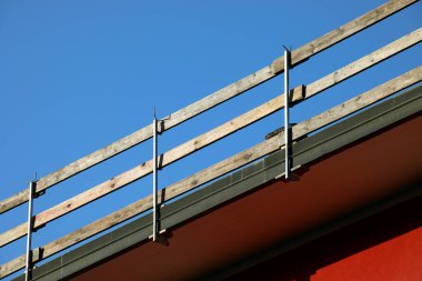 Dayanıklı koruyucu bariyerin ahşap kalasları işçilerin güvenliği için sıkıca yerleştirildi. Dairenin çatısında bakım sırasında insanlar olmadan düşmesinler diye.