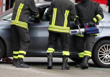 İtfaiyeciler trafik kazasından sonra arabanın kapısını açmak için Jaws of Life adında güçlü bir hidrolik retraktör kullanıyorlar.