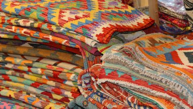 Kilim dükkanında satılık çeşitli stilize geometrik şekillere sahip halıların arka planı