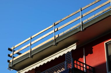 İşçilerin güvenliği için güvenli bir güvenlik bariyeri kurulmuş. Dairenin çatısındaki bakım çalışmaları sırasında insanlar olmadan düşmesinler diye.