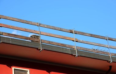 İşçilerin güvenliği için güvenli bir güvenlik bariyeri kurulmuş. Dairenin çatısındaki bakım çalışmaları sırasında insanlar olmadan düşmesinler diye.