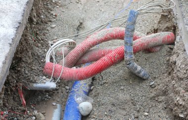 Şehirdeki iş yolları boyunca elektirik kablolarıyla boruları çevreleyin