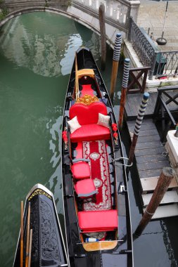 Kuzey İtalya 'da Venedik Adası' ndaki seyyar kanalda kırmızı koltuklu bir gondol gemisi.