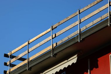 İşçilerin güvenliği için güvenli bir güvenlik bariyeri kurulmuş. Dairenin çatısındaki bakım çalışmaları sırasında insanlar olmadan düşmesinler diye.