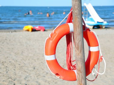 Denizde boğulma sırasında cankurtaranlara yardım etmek için kumlu sahilde can yeleği.