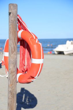 Turuncu can yeleği, kumlu sahildeki bir direkte asılı duran dayanıklı plastikten yapılmış. Cankurtaranların insanları kurtarması için.