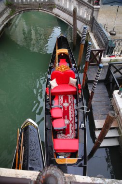Kuzey İtalya 'daki Venedik Adası' ndaki seyyar kanalda kırmızı koltuklu gondol teknesi.