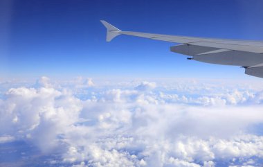 Yükseklerden gelen kanat ve beyaz bulutların uçtuğu uçak ideal bir seyahat konsepti olarak görülüyor.