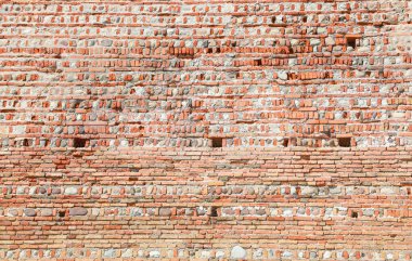 Köyü koruyan eski bir ortaçağ duvarının birçok tuğlasının arka planı.