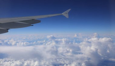 yumuşak bulutlar uçaktan 6500 metre yüksekte kanadın bir kısmına bakıyor.