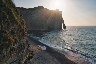 Gün batımında Etretat plajının fotoğrafı.