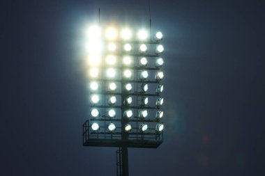 Futbol sahası için projektör, alacakaranlıkta bir sürü lamba. Yüksek kalite fotoğraf