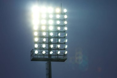 Futbol sahası için projektör, alacakaranlıkta bir sürü lamba. Yüksek kalite fotoğraf