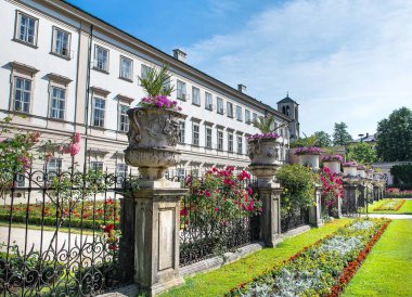 Salzburg Avusturya 'da Mirabell bahçesindeki bir binanın etrafındaki çiçekler.