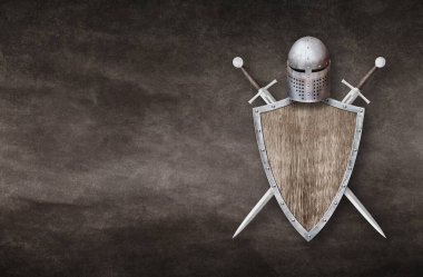 Şövalye miğferi ahşap kalkan ve arka planda iki kılıç.
