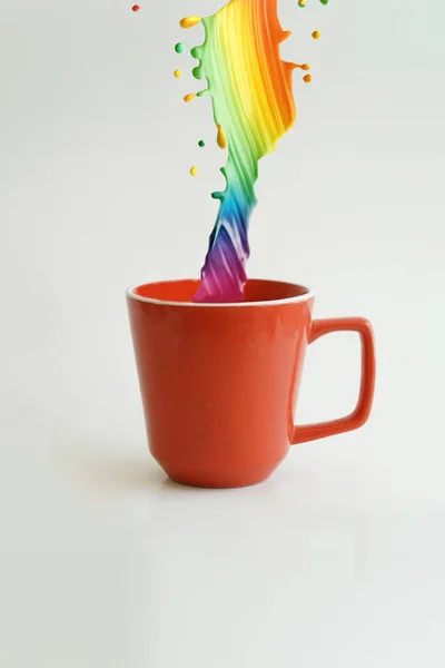 白い背景に対する1滴の低下のコーヒーの赤いカップ ストック画像