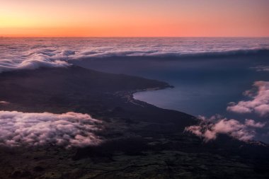 Beautiful landscape view of sunrise over clouds, ocean and coastline viewed from Mt Pico on Azores, Portugal clipart