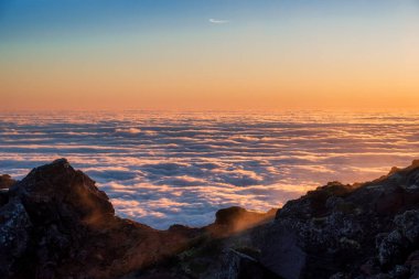 Renkli gündoğumu manzarası güzel bulutlar ve kaya önplanı ile, Pico Dağı, Azores, Portekiz