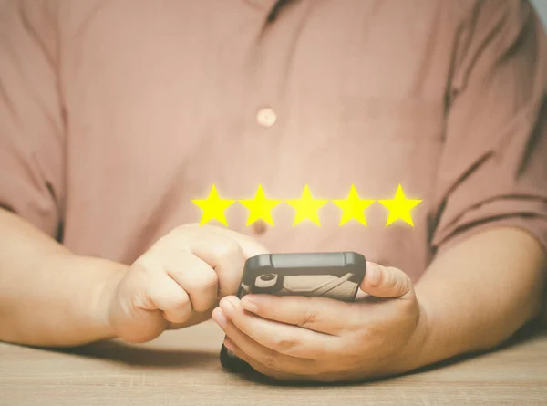Cep telefonu kullanan müşteriler başvuru yoluyla 5 yıldızlı memnuniyetlerini sunuyorlar. memnuniyet anketi İş tecrübesi Müşteri Anketi Kavramı.
