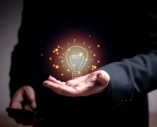 Businessman holding a light bulb, Concept of Ideas for presentation new ideas Great inspiration and innovation. team brainstorming Finding new ideas at work.