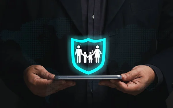 Aile güvenliği kavramı. Akıllı telefon sanal ekranı elinde tutan bir iş adamı, aile simgesi güvenlik simgesinde. sigorta işi, hayat sigortası, gelecek planlama uzun vadeli finansal yatırım.