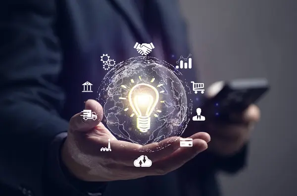 İş adamı elinde bir ampul tutuyor ve internete bağlı sanal bir küreye sahip. Cep telefonu, finans, bankacılık, çevrimiçi pazarlama, endüstri, eğitim, büyük veriler yoluyla dijital çağda pazarlama.