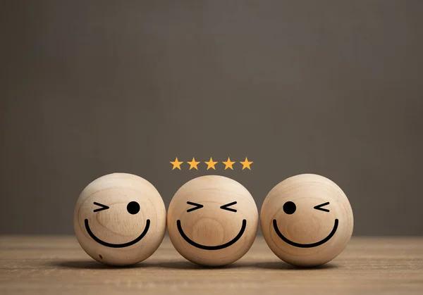 The concept of service satisfaction A smiley face ball is placed on the table and there is a gold star on the ball. The customer feedback survey rating. Business excellent score. Good evaluation emotion.