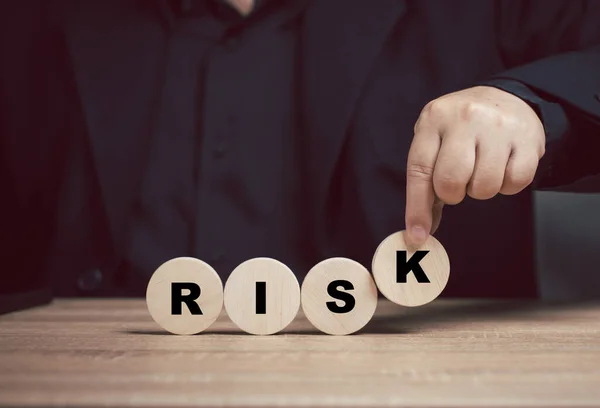Risk management concept. Man places the letter risk on the table. Organizational management. Reduction. Strategy solution investment for risk. Safety economy finance in control.