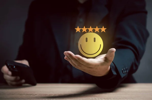man shows yellow smiley face on hand. The concept of maximum customer satisfaction. poll Answering questionnaires. scoring. feedback. Give star for good choice performance.