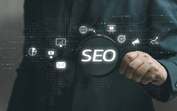 man holds a magnifying glass to search tools for SEO Marketing. SEO strategy that uses customizing and optimizing the website or content of that online business so that it can rank on search engines.