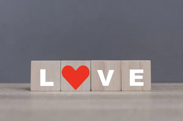 The concept of love. wood cube with letters LOVE and hearts placed on the table. valentine\'s day love. The emotion romance for cupple and frined.