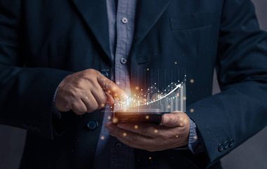 İşadamı, stok grafiğindeki sanal cep telefonu ekranını işaret ediyor. Cep telefonuyla hisse senedi ticareti kavramı. Finansal borsa grafiği. Hisse senedi ve bitcoin parası. Çevrimiçi ticaret. 