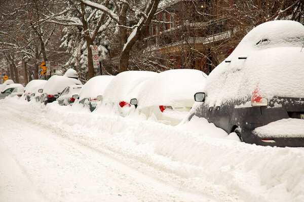 The street and cars are full of snow after a big snowstorm during winter season in Montreal, Quebec.  More than 30 cm in 1 day on the city.
