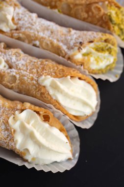 Taze cannoli doğası ve fındıklı siyah bir arka plan.
