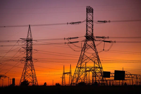 カナダの日没の空に高電圧電力パイロンのグループ ストック写真