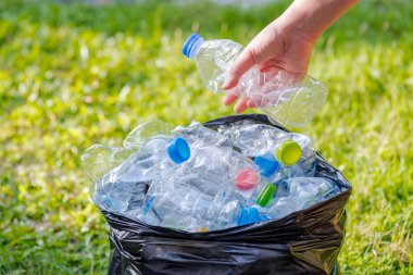 Siyah çöp torbalarındaki plastik şişeler geri dönüşüm için alınmayı bekliyor..