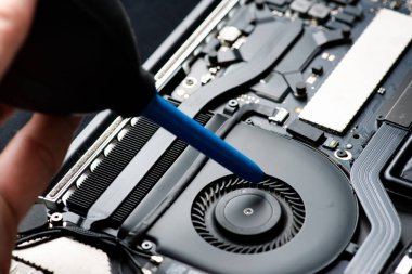 Elektronik devre kartlarını tamir eden teknisyenleri kapatın, ana kartı elektrikli süpürgeyle tamir edin.