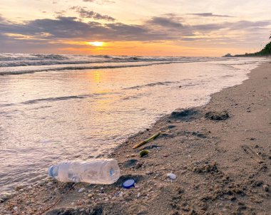 Kirli deniz kumlu kıyı, çevresel kirlilik, okyanustaki plastik su şişeleri kirliliği 