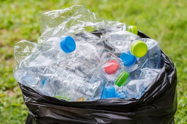 Siyah çöp torbalarındaki plastik şişeler geri dönüşüm için alınmayı bekliyor..