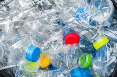 Siyah çöp torbalarındaki plastik şişeler geri dönüşüm için alınmayı bekliyor..