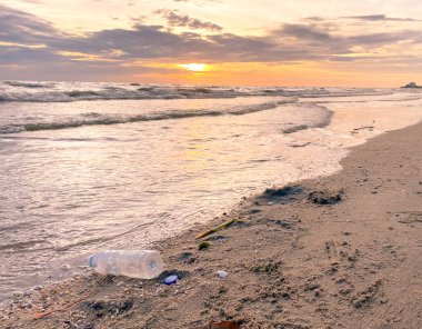 Kirli deniz kumlu kıyı, çevresel kirlilik, okyanustaki plastik su şişeleri kirliliği 