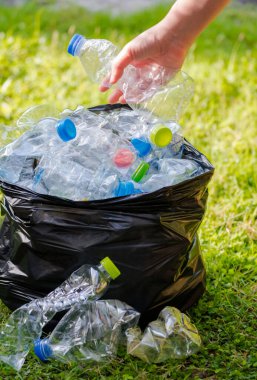 Siyah çöp torbalarındaki plastik şişeler geri dönüşüm için alınmayı bekliyor..