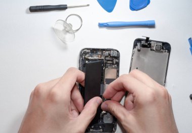 Belgili tanımlık smartphone zarar ve tamirci eller tarafından izole üzerinde beyaz arka plan ayakta hangi araçları akıllı telefon tamir gerek yapıldı..